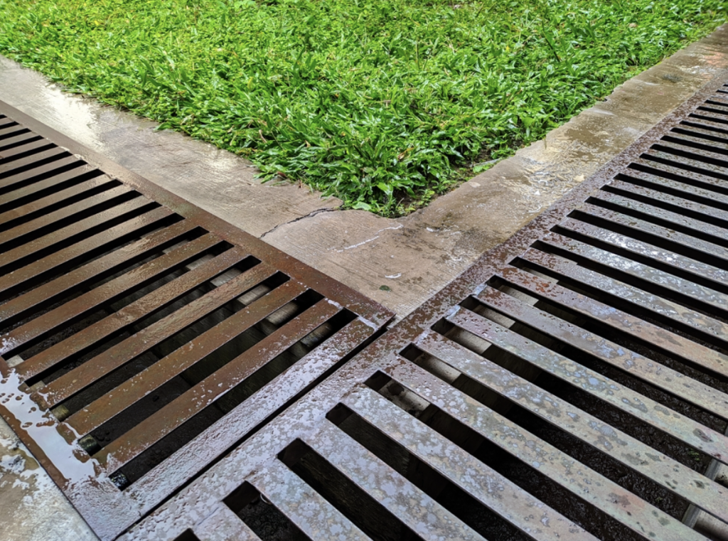 Drainage system | Metal drainage grates next to grassy patch.