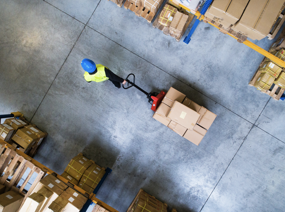 Warehouse floor refurbishment | Person pulling cart in warehouse, top-down view.