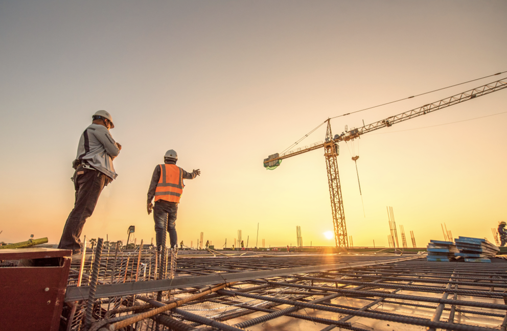 Construction project management | People on a building site with a crane in the background