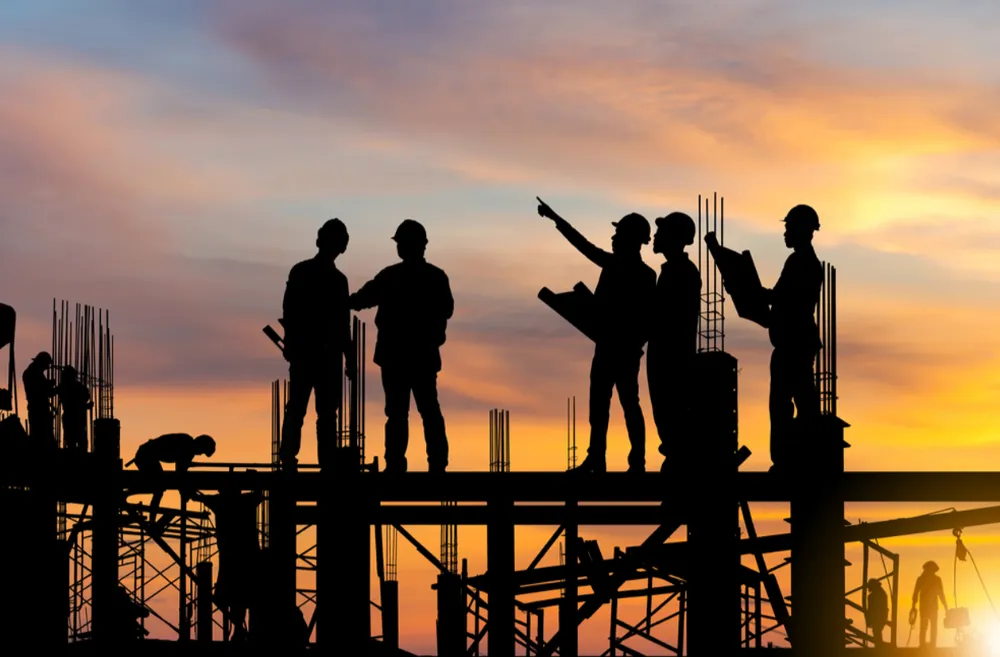 Industrial construction | Figures in silhouette on top of a building site.