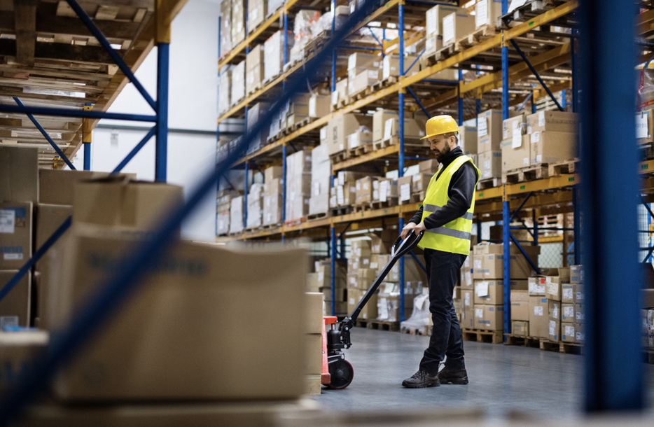 industrial fit-out | Person in warehouse moving boxes.