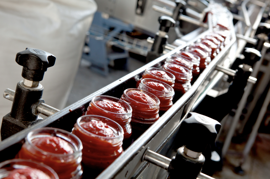 Factory fit-out | jars of food rolling down a factory line.